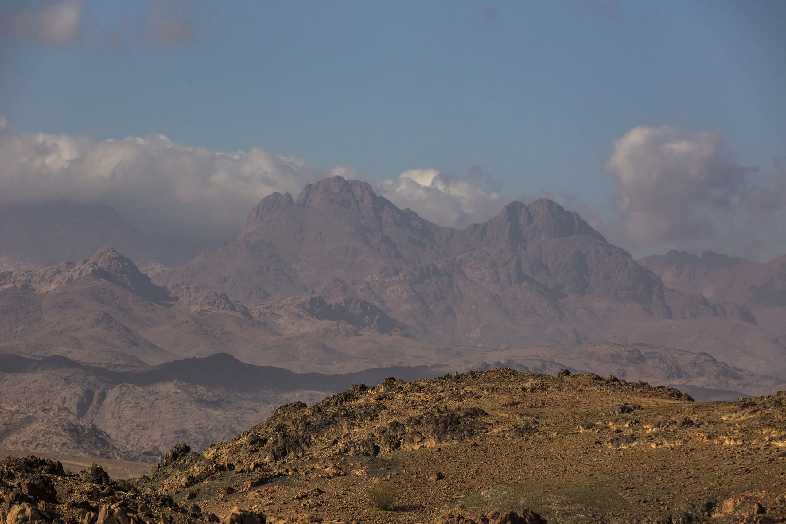 Jebel al-Lawz rising beyond a rocky desert foreground beneath a wide blue sky.